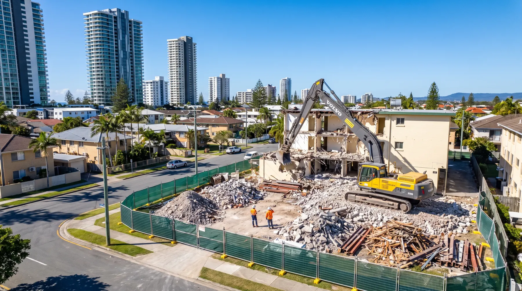 Excavator demolishing an old unit block in Broadbeach, with the Surfers Paradise and Broadbeach highrises behind