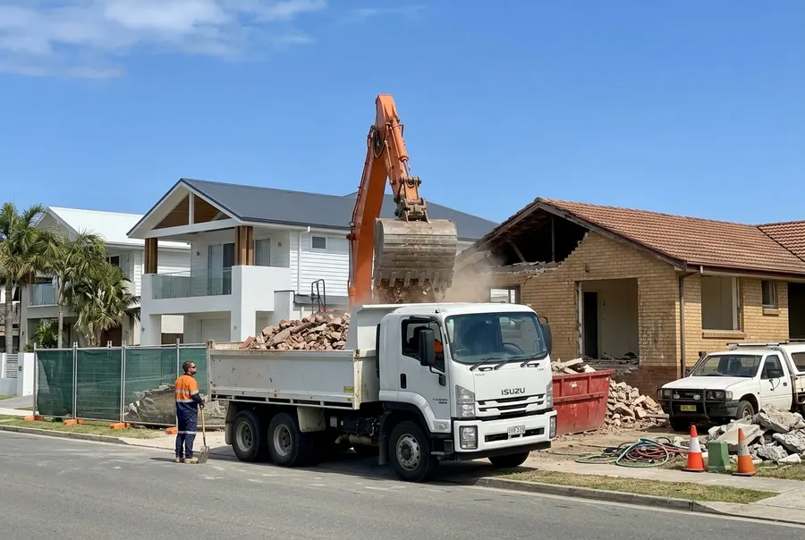 Rubble being loaded into a tipper truck at a brick house demolition
